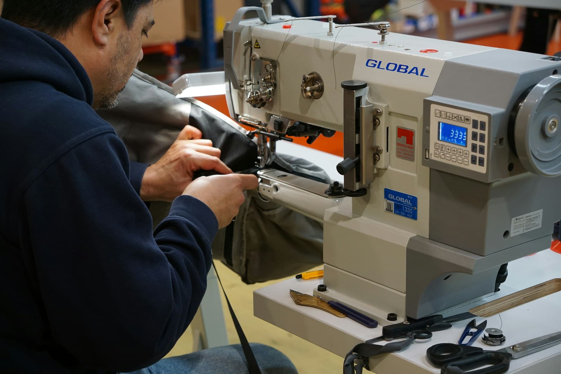 Hands at work on a sewing machine — Rishabh Bags workshop